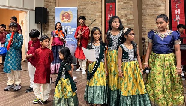 Children dancing in festive dress during a programme