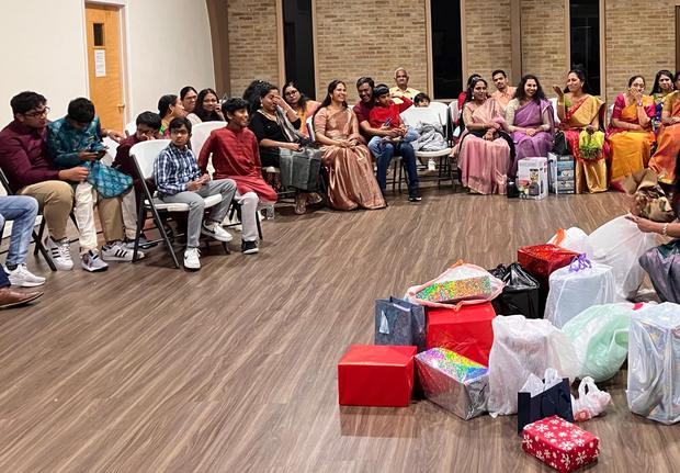 The fellowship seated together with gifts gathered for giving