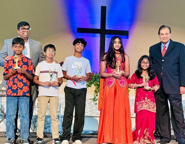 Children and youth receiving trophies on stage