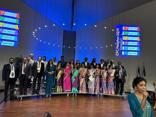 The choir and leaders on stage at a conference