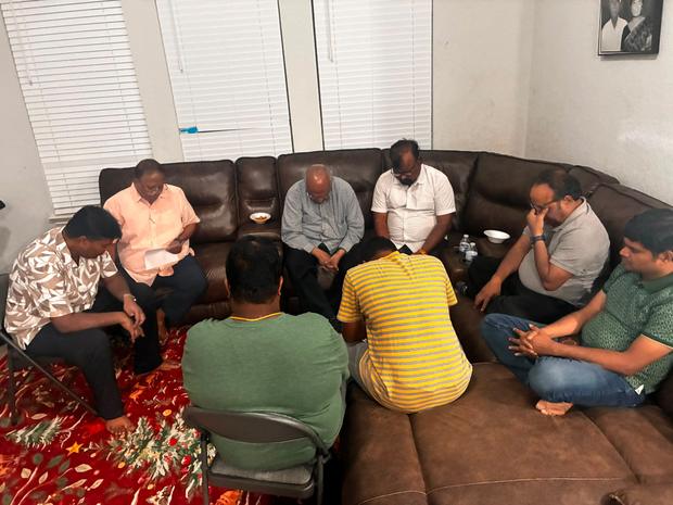 Members praying together in a home