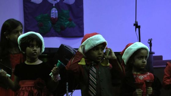 Children of the fellowship in Christmas hats singing at the 2014 Christmas programme
